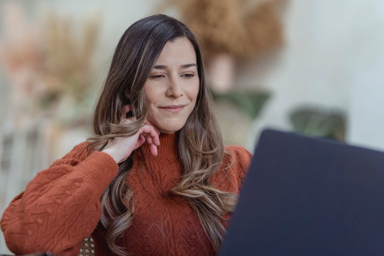 Smiling woman browsing laptop for remote job